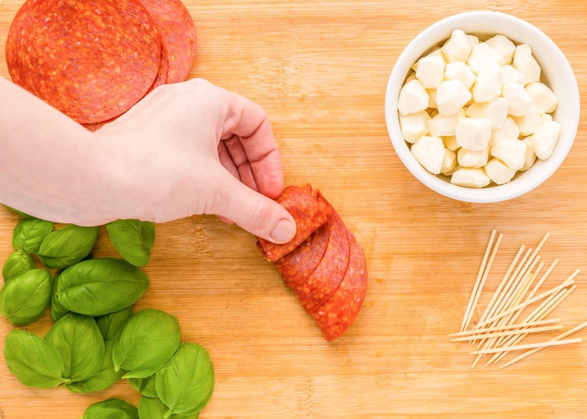 Create beautiful {and delicious} pepperoni rose skewers with only 3 ingredients and a few simple steps - a picture-perfect appetizer! Rolling folded pepperoni in a roll.